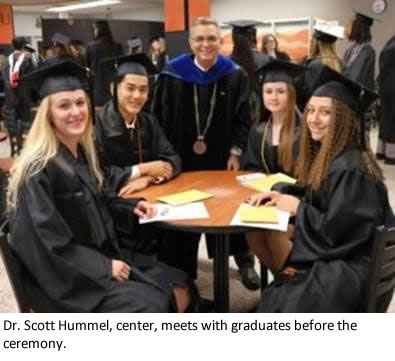 Dr. Scott Hummel, center, meets with graduates before the ceremony.